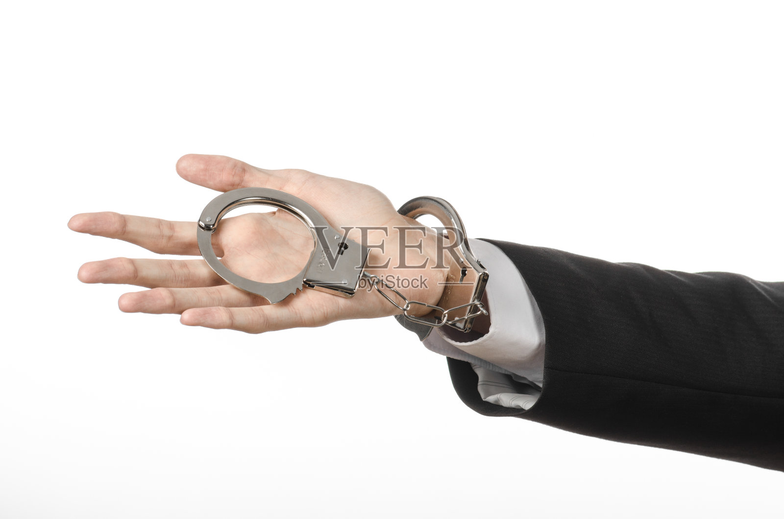 腐败与贿赂主题:商人身穿黑色西装,双手戴着手铐,以白色为背景,在演播室孤立照片摄影图片