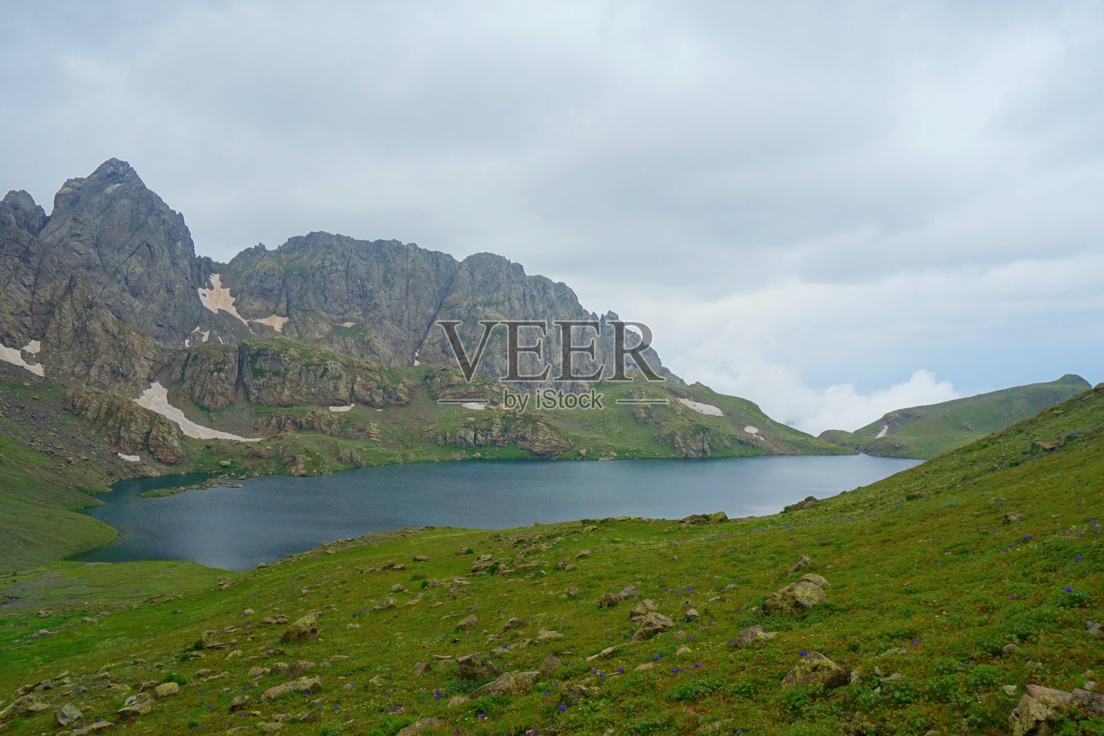 在格鲁吉亚的银湖徒步旅行时,在高加索山脉有一个白雪皑皑的山口照片摄影图片