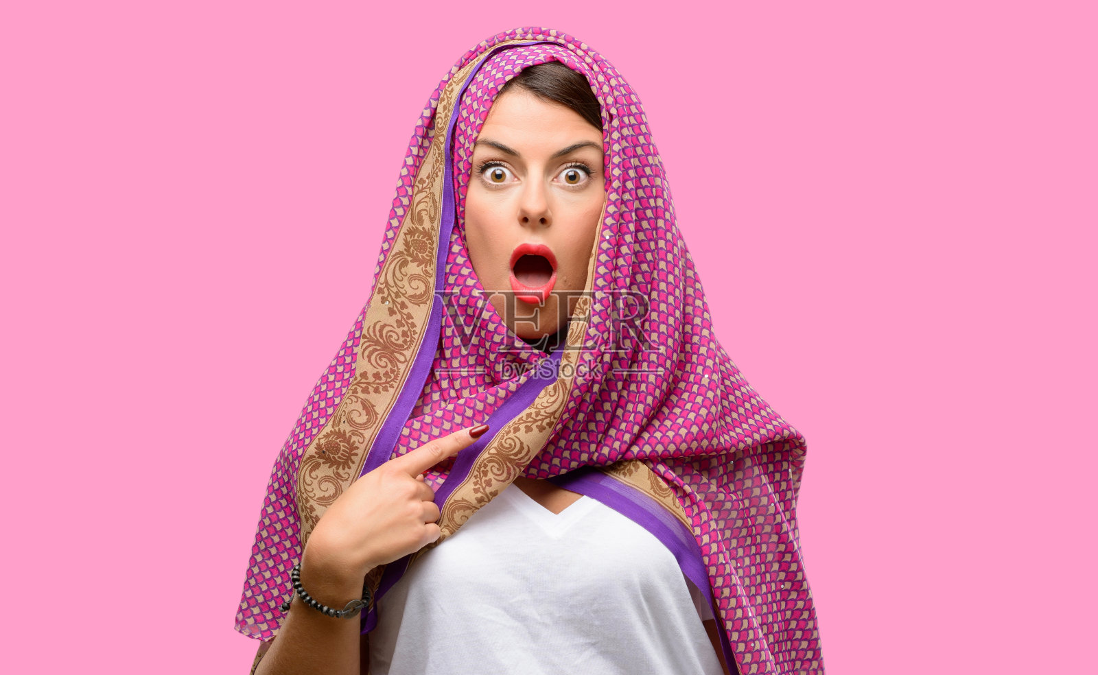 年轻的阿拉伯妇女戴着头巾,高兴和惊讶的欢呼,表示哇手势,用手指照片摄影图片