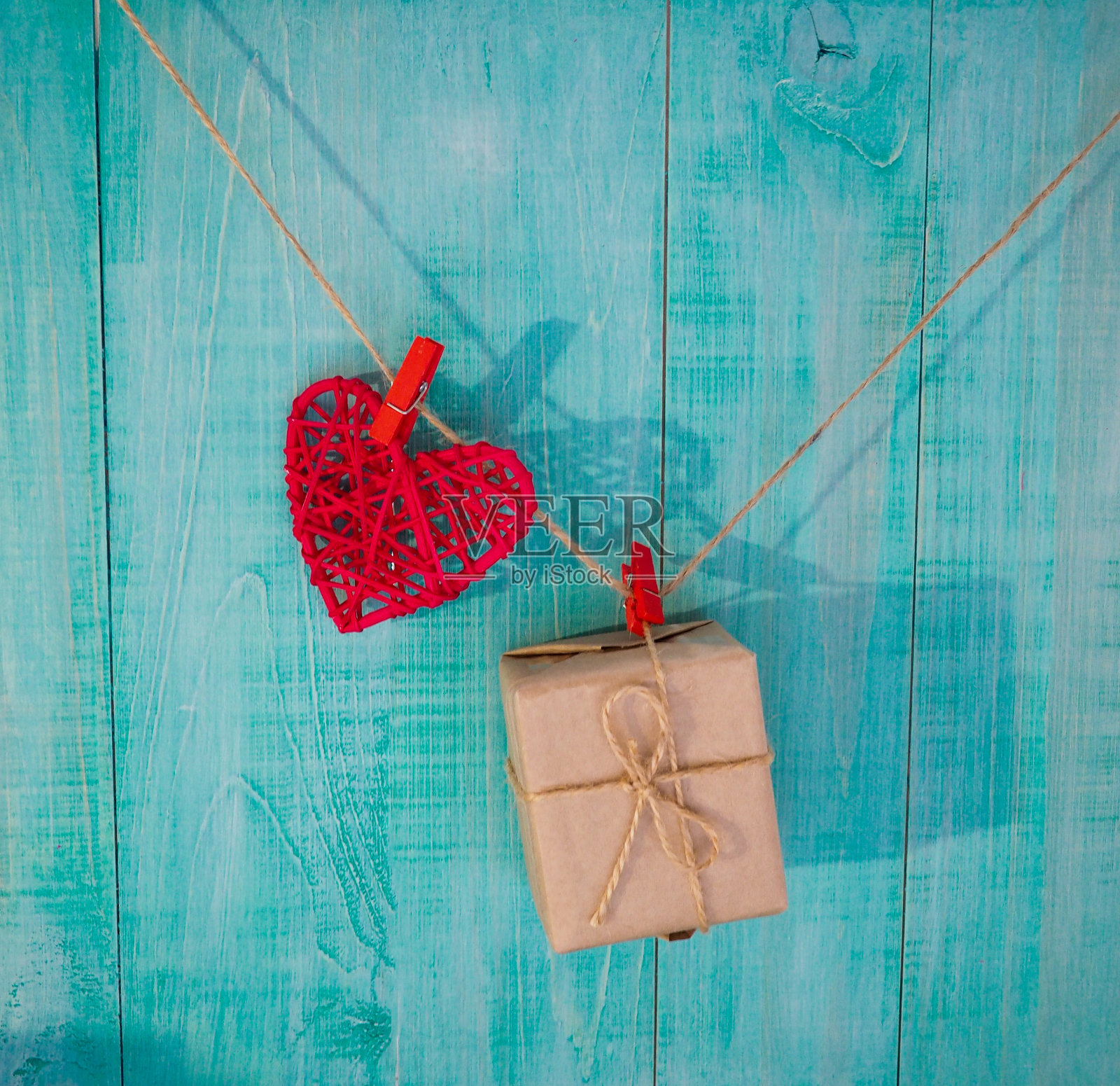 红色的乡村布心挂在晾衣绳上用乡村木门装饰情人节、母亲节和爱情概念背景用木质复制空间照片摄影图片