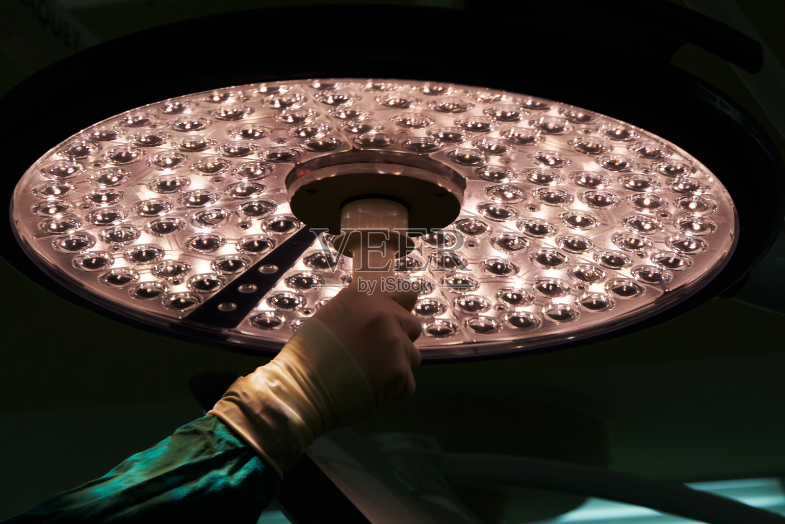 医生手持并调节手术灯照片摄影图片