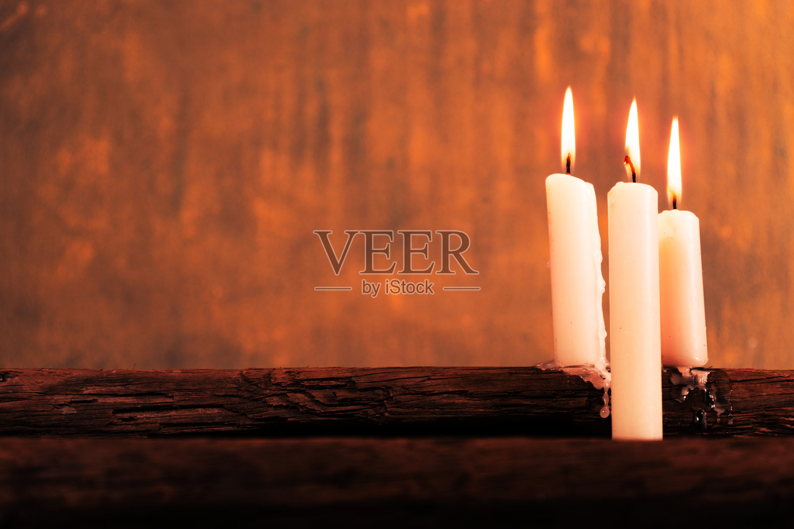 老橡木木桌上放着蜡烛。美丽的金色背景。宗教的概念。照片摄影图片