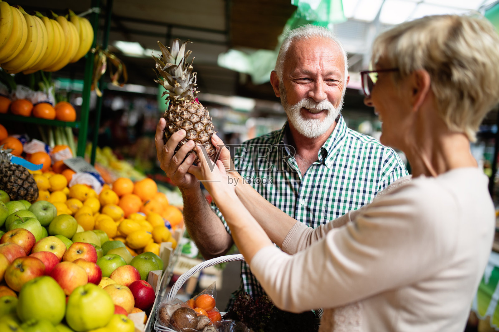 微笑的老年夫妇在市场上买菜照片摄影图片