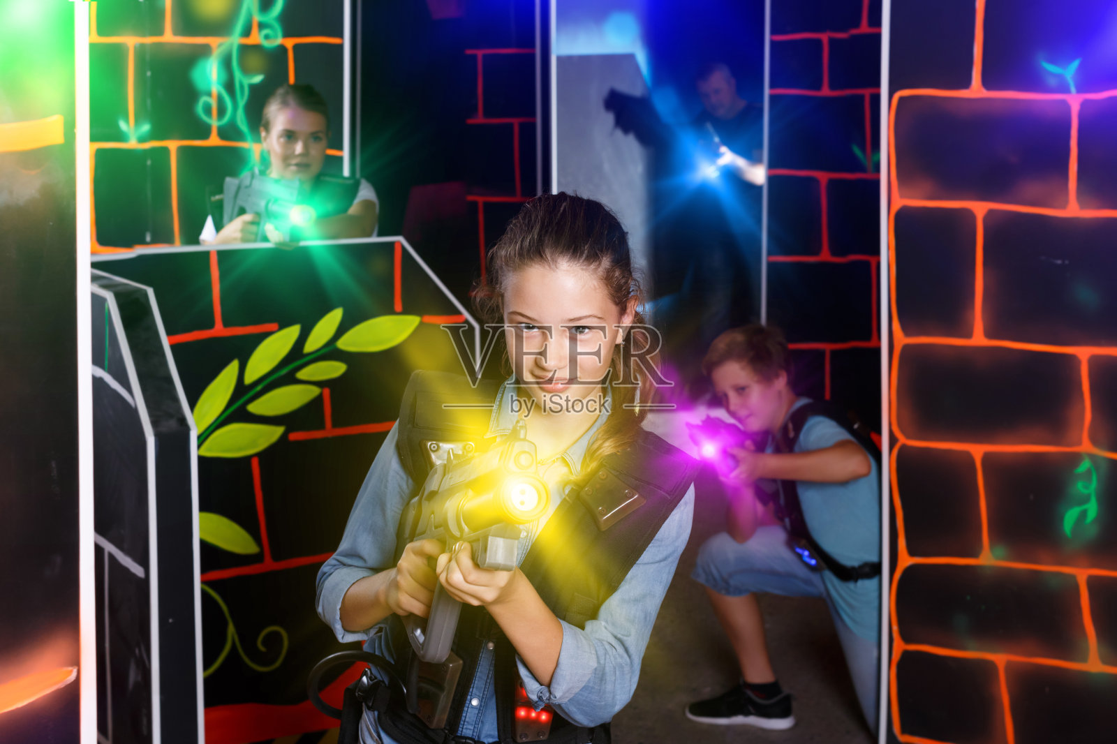 积极的女孩用激光枪瞄准其他玩家照片摄影图片