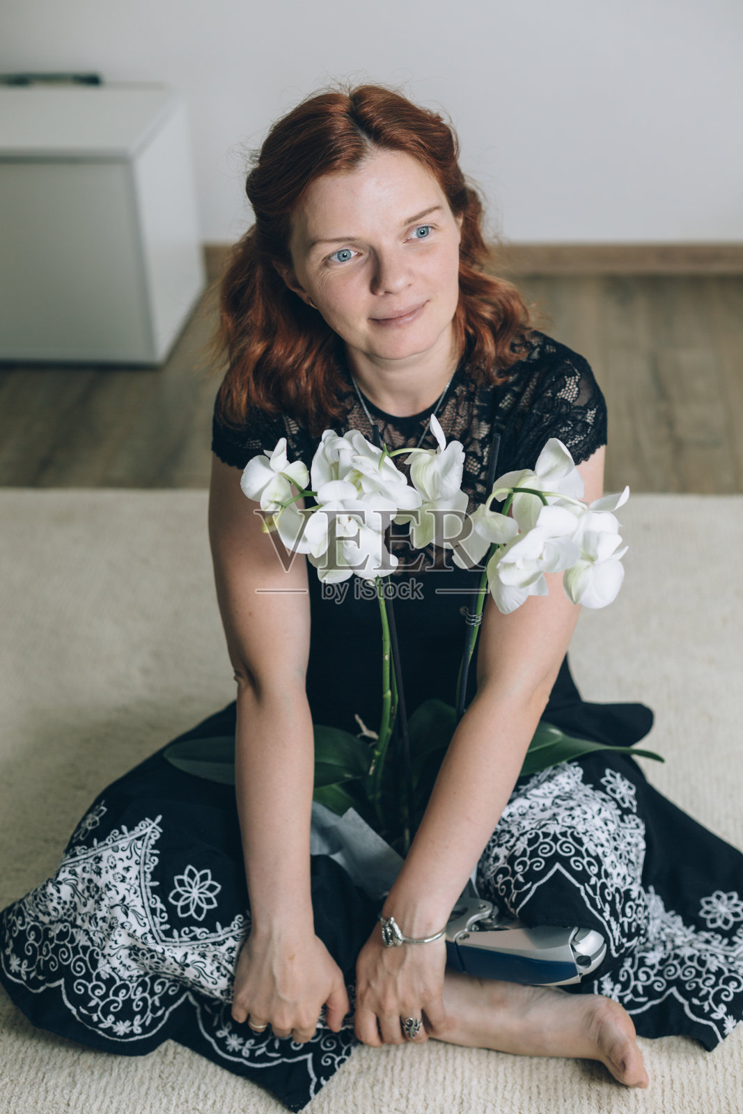 女假肢在瑜伽姿势与鲜花照片摄影图片