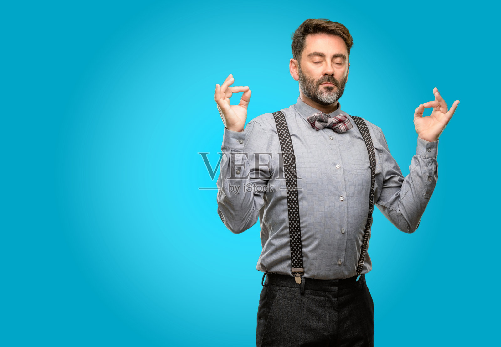 中年男子,留着胡子,打着领结,双手做着不错的手势,表示沉思和放松照片摄影图片