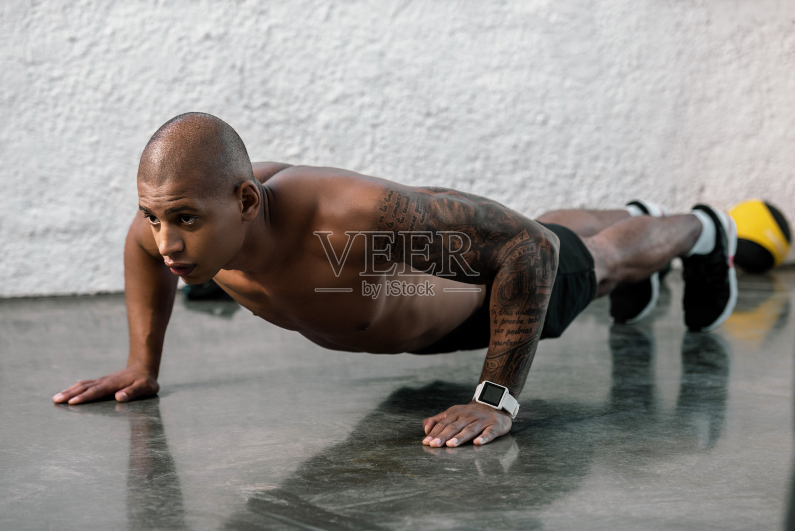 肌肉发达的年轻非裔美国人赤膊在健身房做俯卧撑照片摄影图片