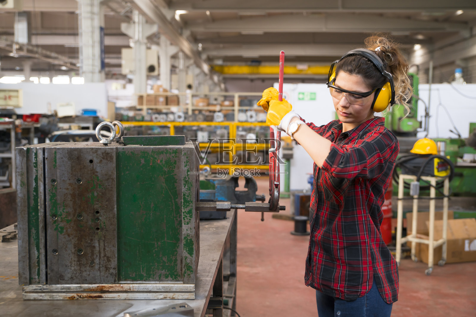 一名妇女在一家金属制造公司的铣床上工作照片摄影图片