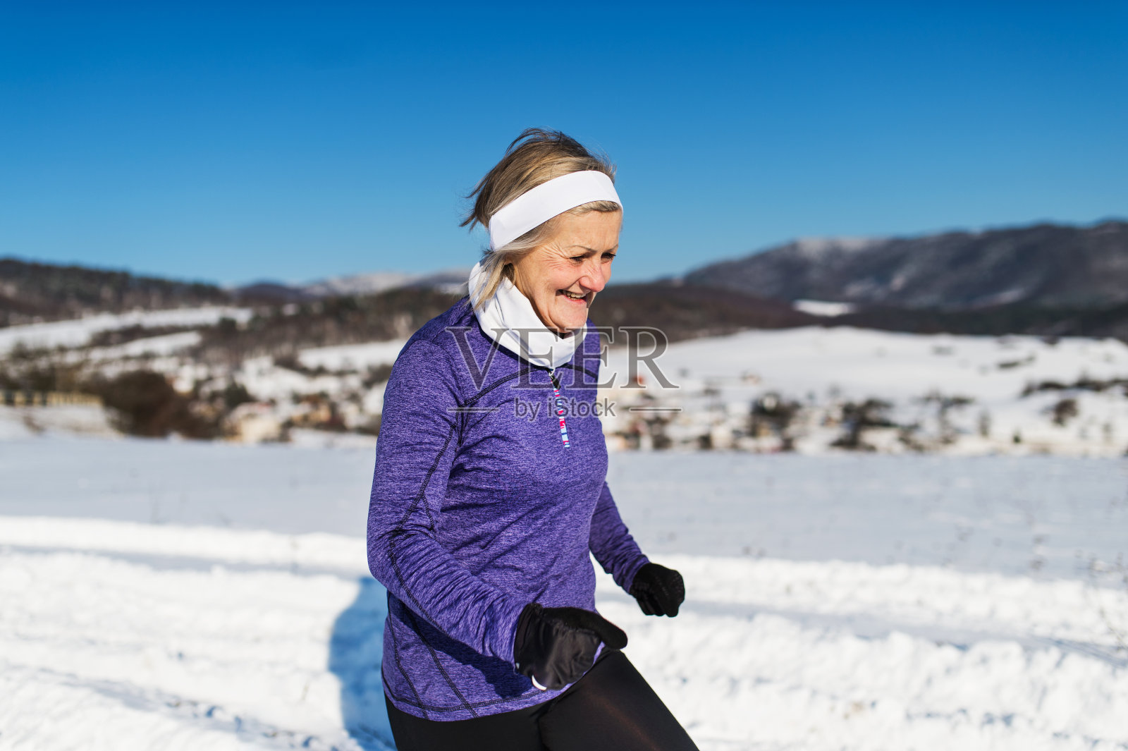 老年女子在冬季自然慢跑。副本的空间。照片摄影图片