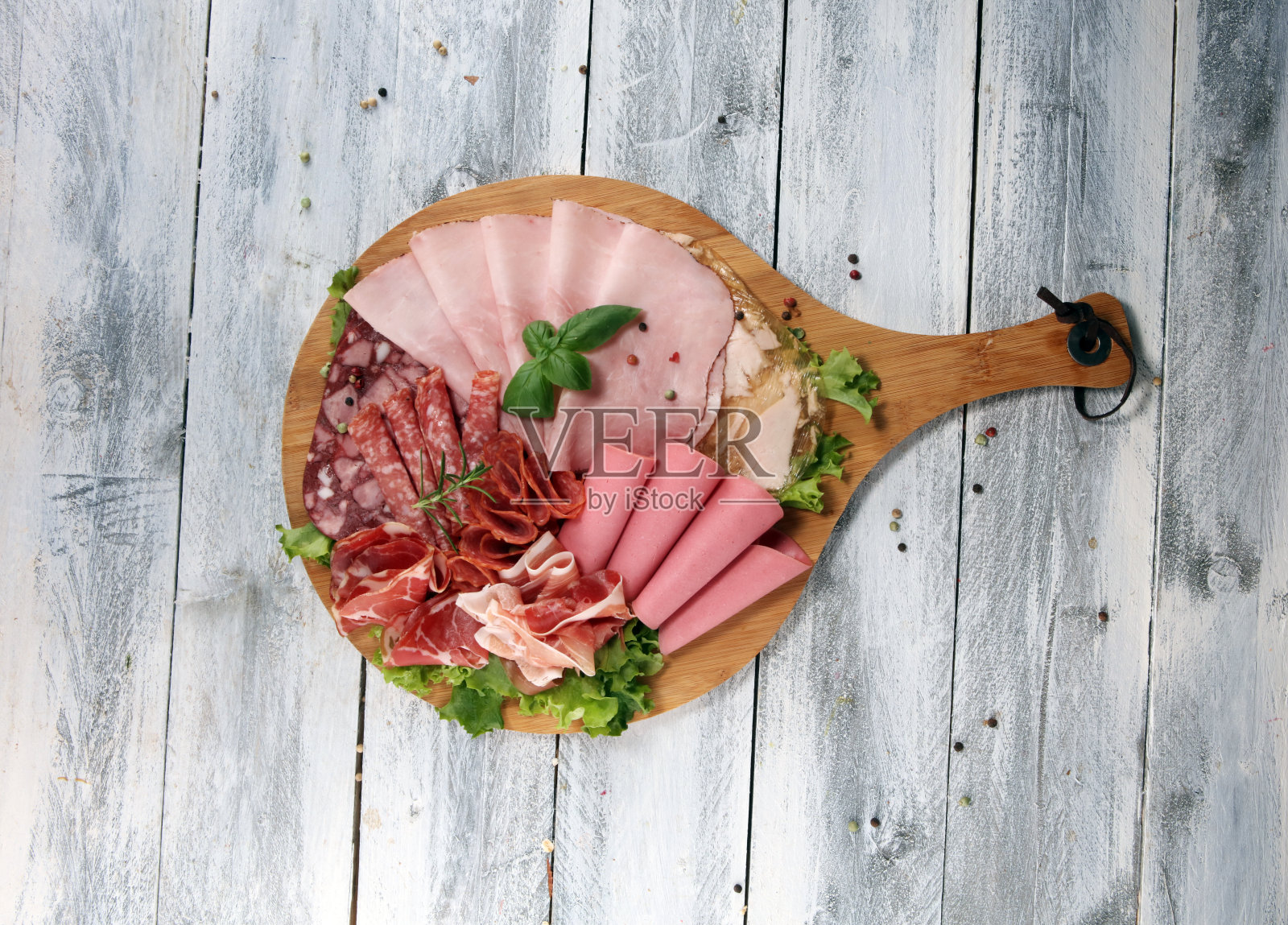 食物托盘里有美味的意大利腊肠,火腿片,香肠和沙拉。有选择的肉拼盘。照片摄影图片