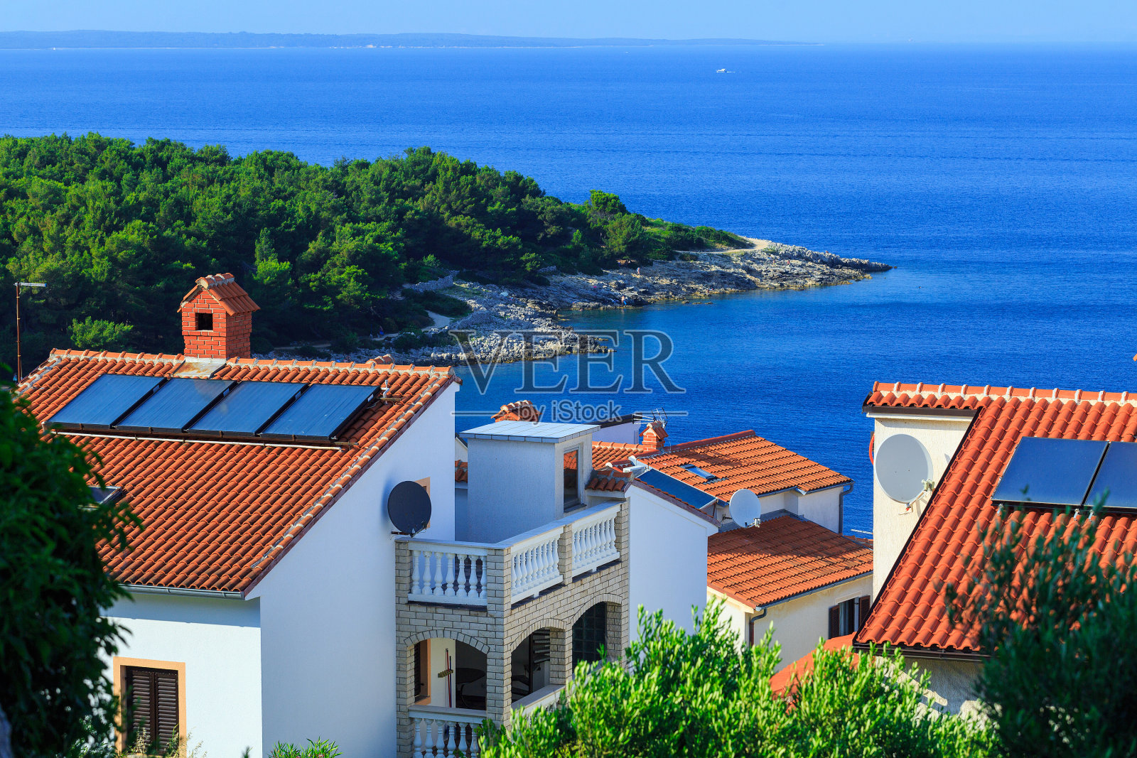 传统的欧洲地中海建筑风格,街道和房屋的陶瓦屋顶,柏树,棕榈树,橄榄,松树包围,海岸蔚蓝的海洋。著名地产的位置照片摄影图片