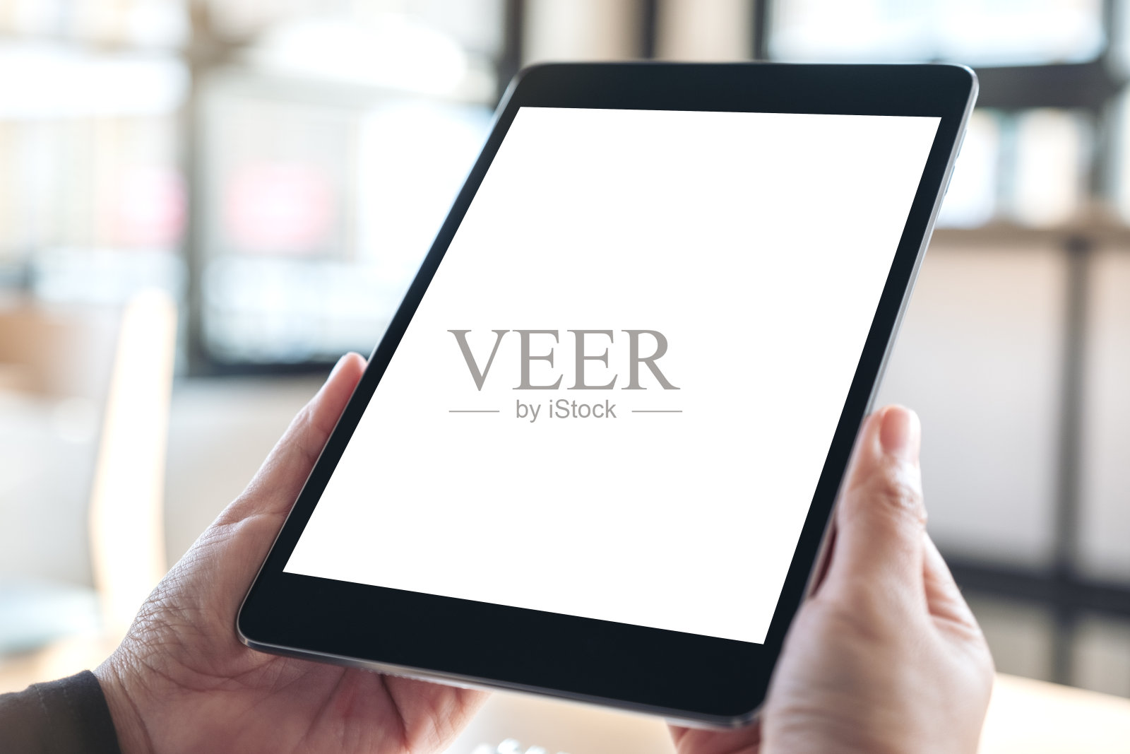 手握和使用黑色平板电脑与空白的白色桌面屏幕的模型图像照片摄影图片