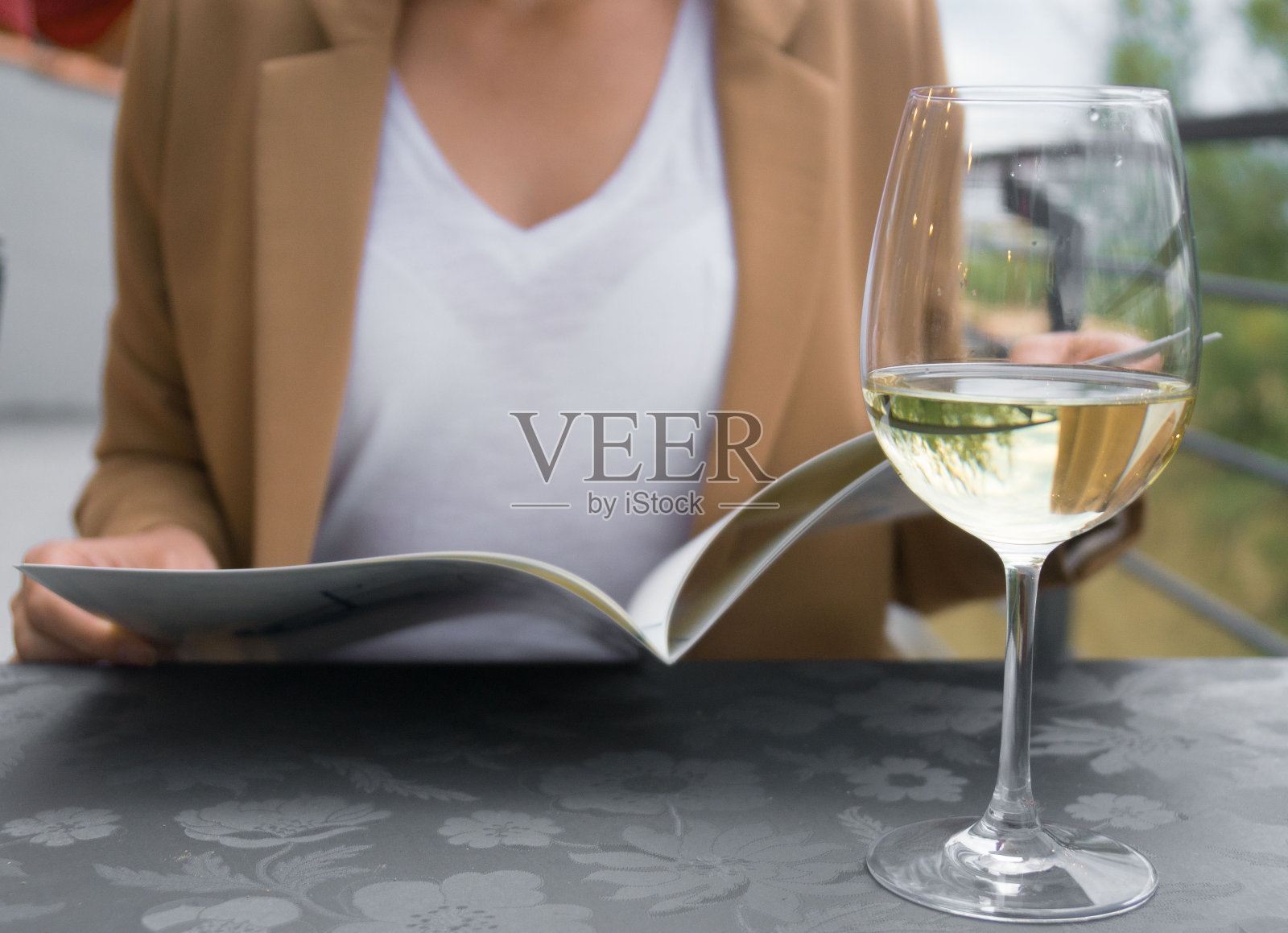 在餐馆用菜单点菜的女人。照片摄影图片