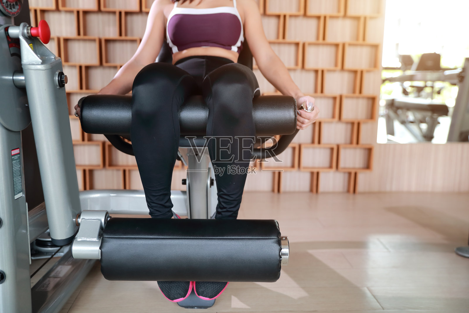 健康和运动的年轻女性在健身房使用锻炼机器的肖像(此图像用于健身和锻炼的概念)照片摄影图片