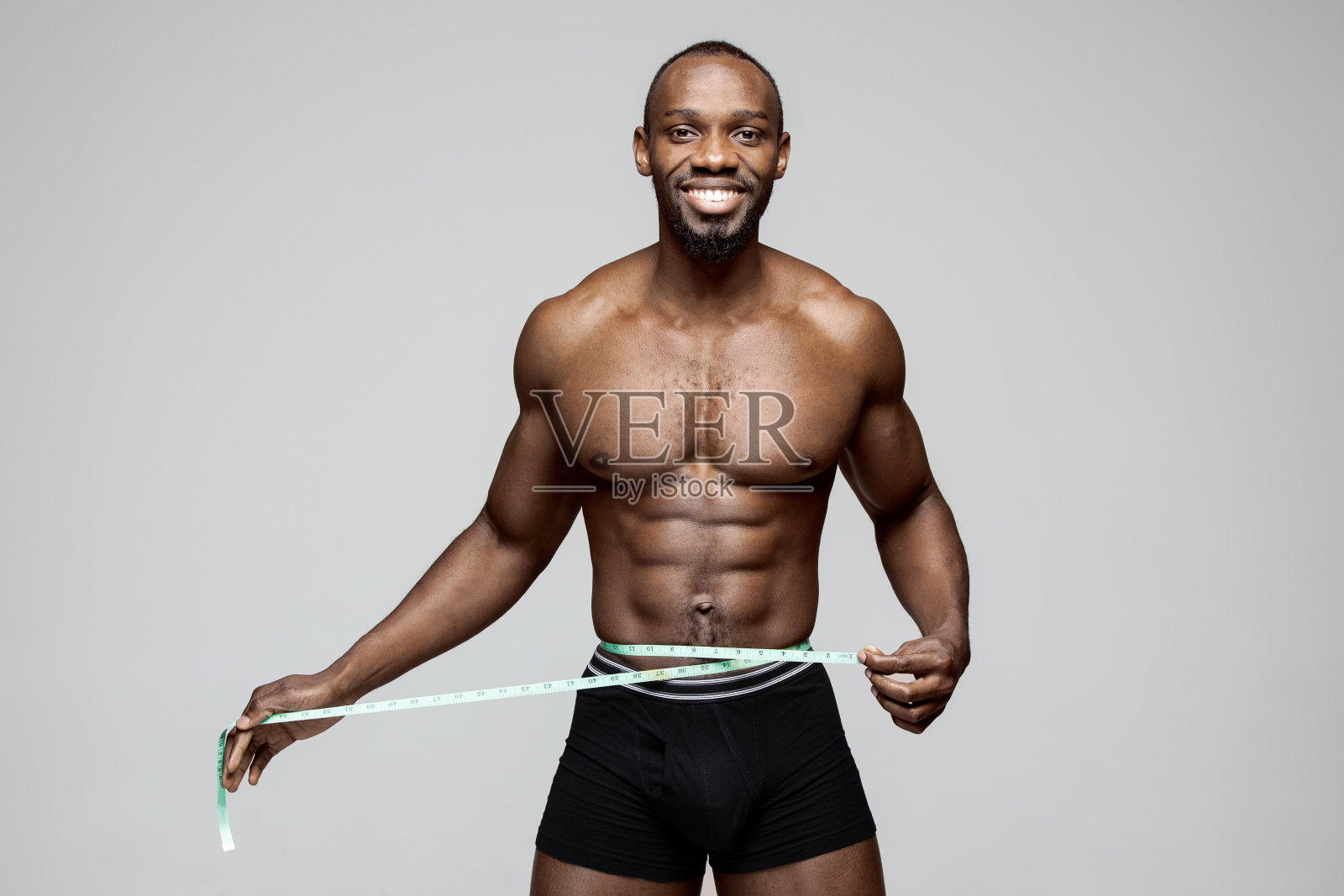 健康的年轻人,躯干漂亮,灰色背景照片摄影图片