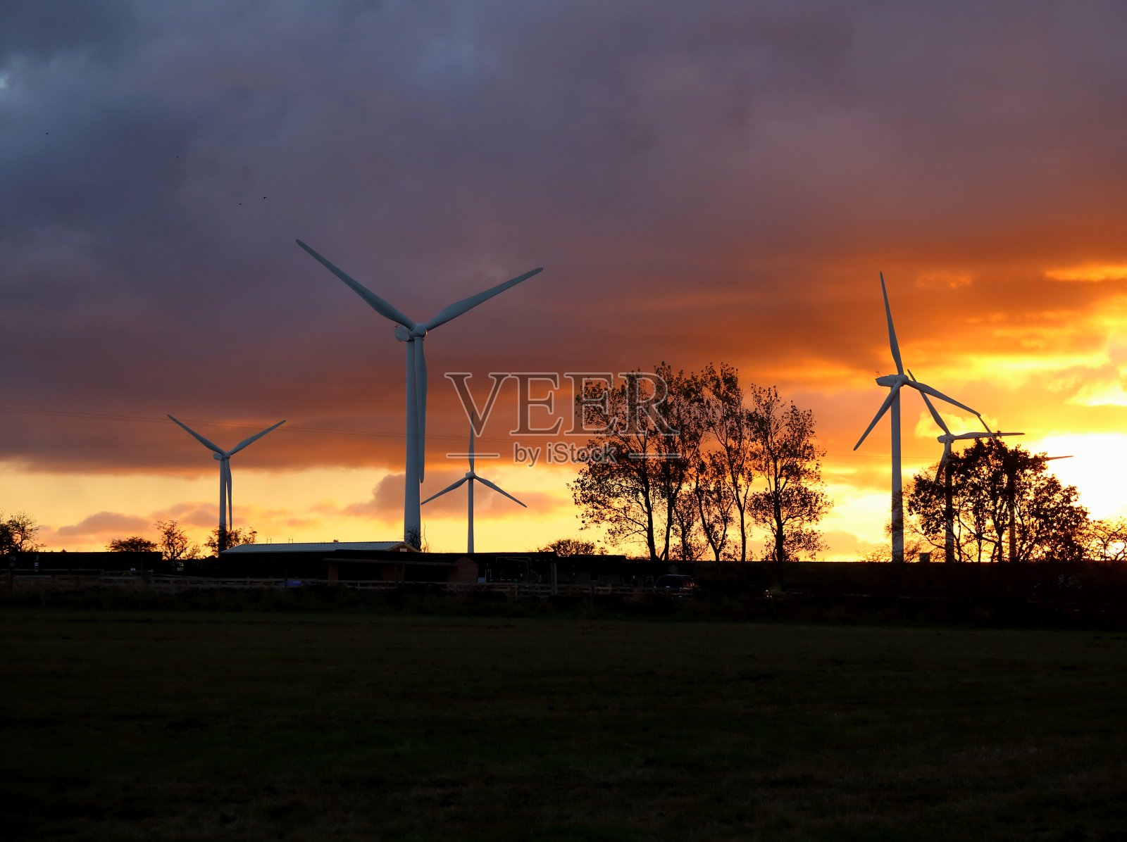 日落时的风力发电机。照片摄影图片