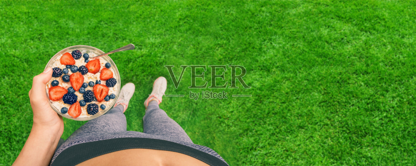 一个小女孩在锻炼后吃着浆果燕麦粥。照片摄影图片