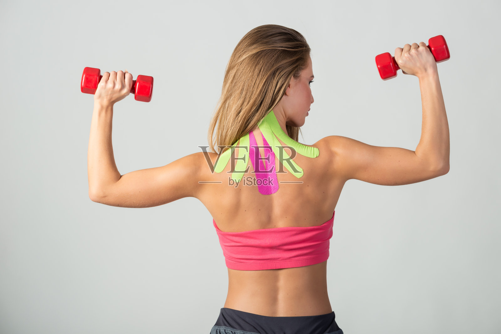 在一个女孩的后背和脖子上贴肌内肌贴照片摄影图片