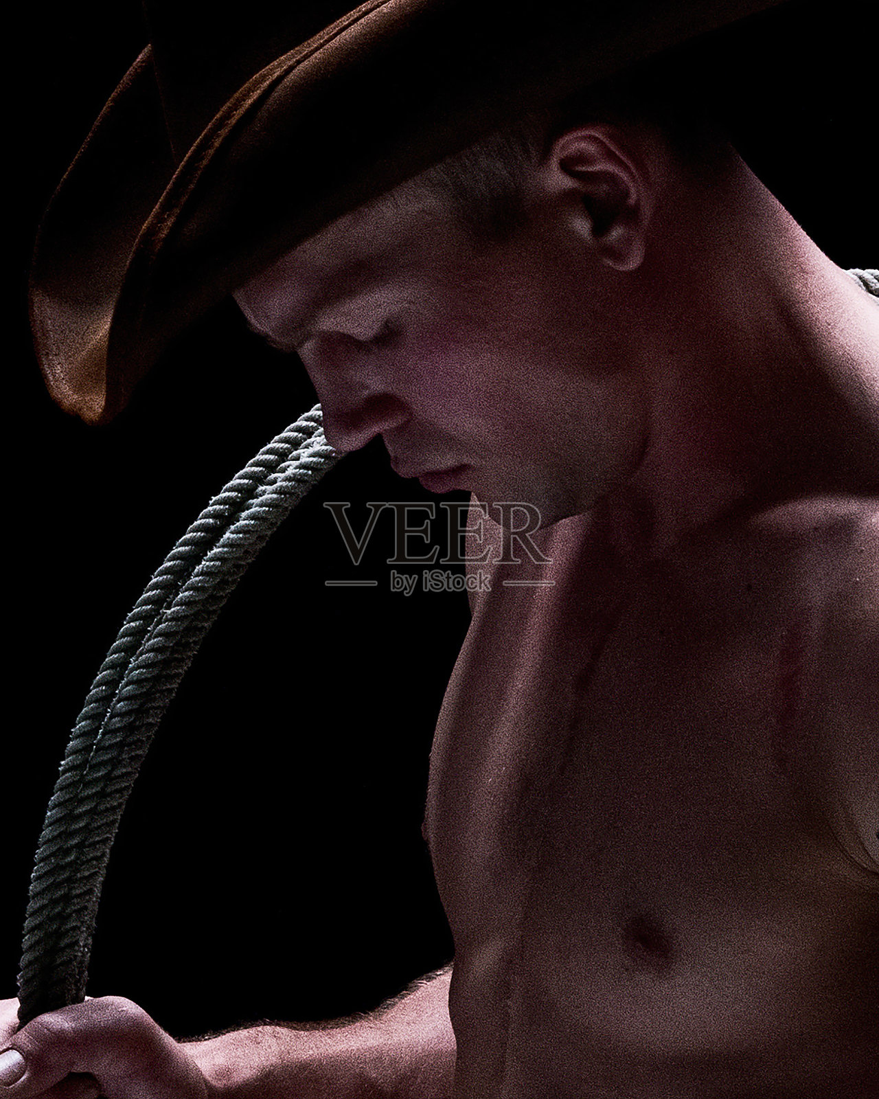 有吸引力的男性牛仔谁是赤膊和持有套索照片摄影图片