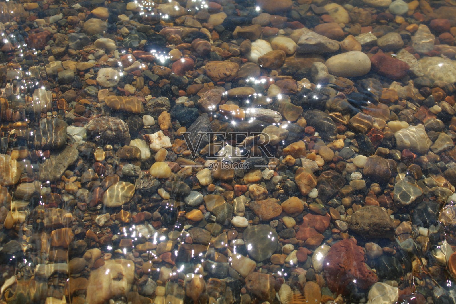 多色的石头在清澈的水照片摄影图片