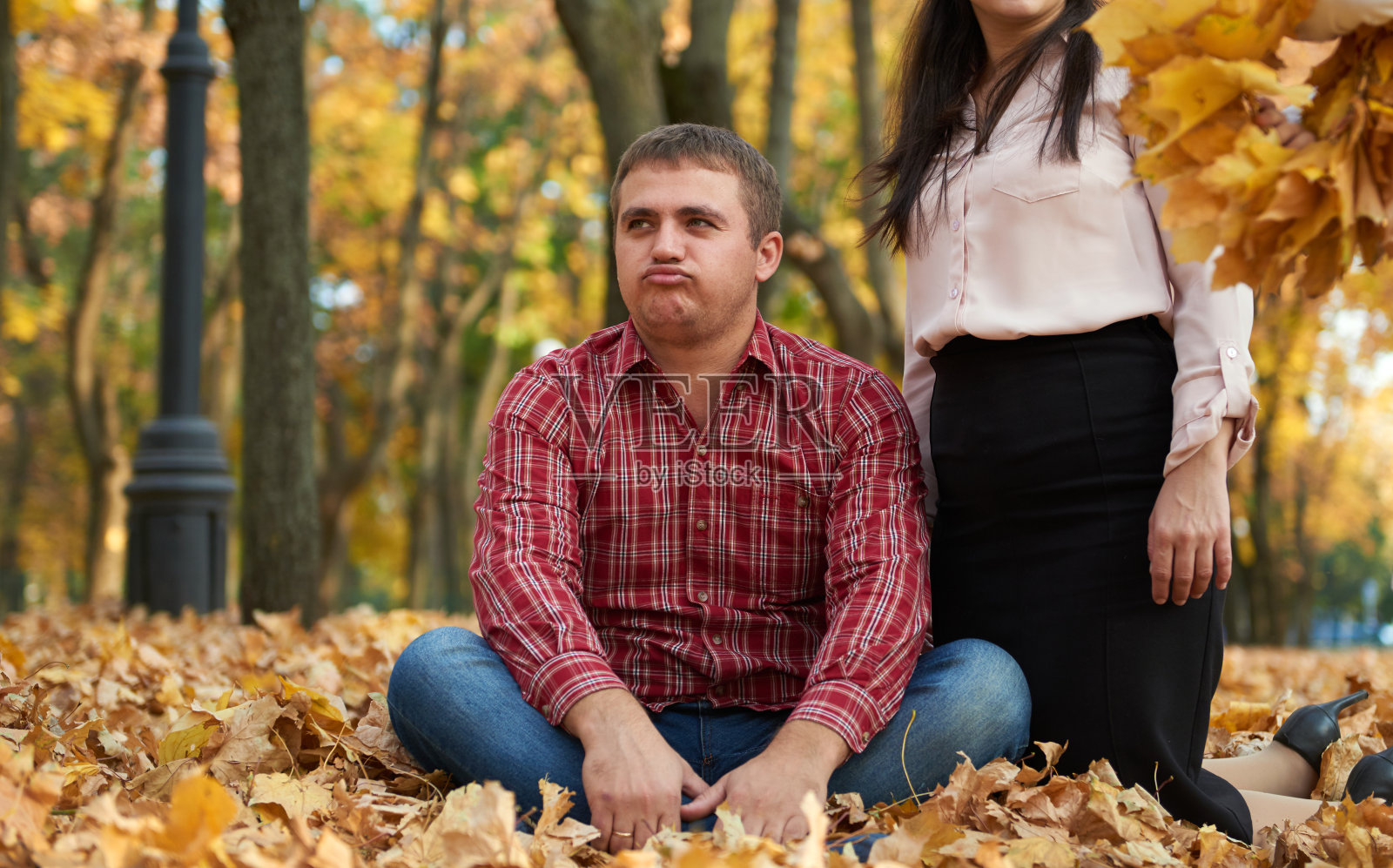 男人在秋天的城市公园累了。不高兴的情绪。照片摄影图片