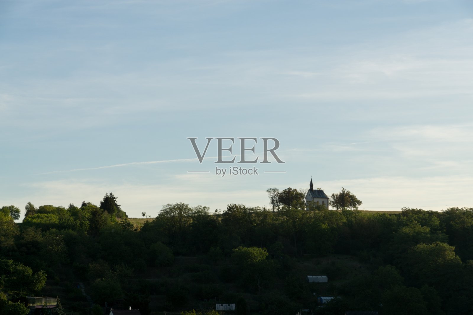 日出时山上的小教堂。照片摄影图片