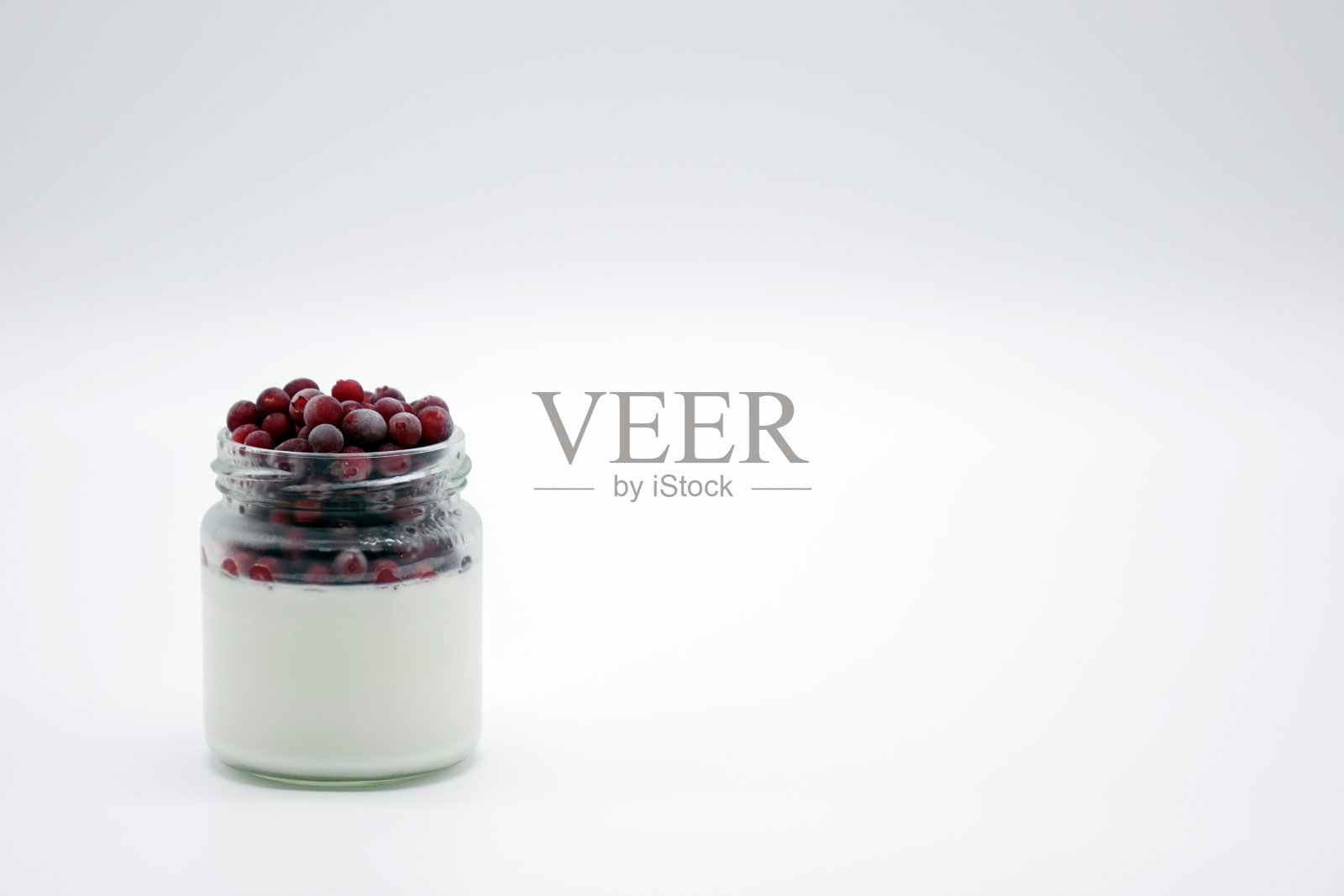 新鲜浆果和酸奶一起放在罐子里。在白色背景上。照片摄影图片