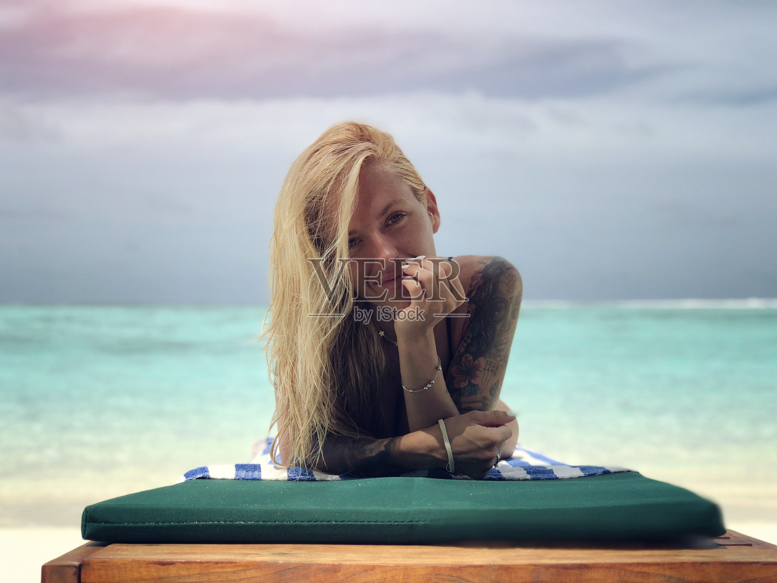 热带海滩上有纹身的女人照片摄影图片