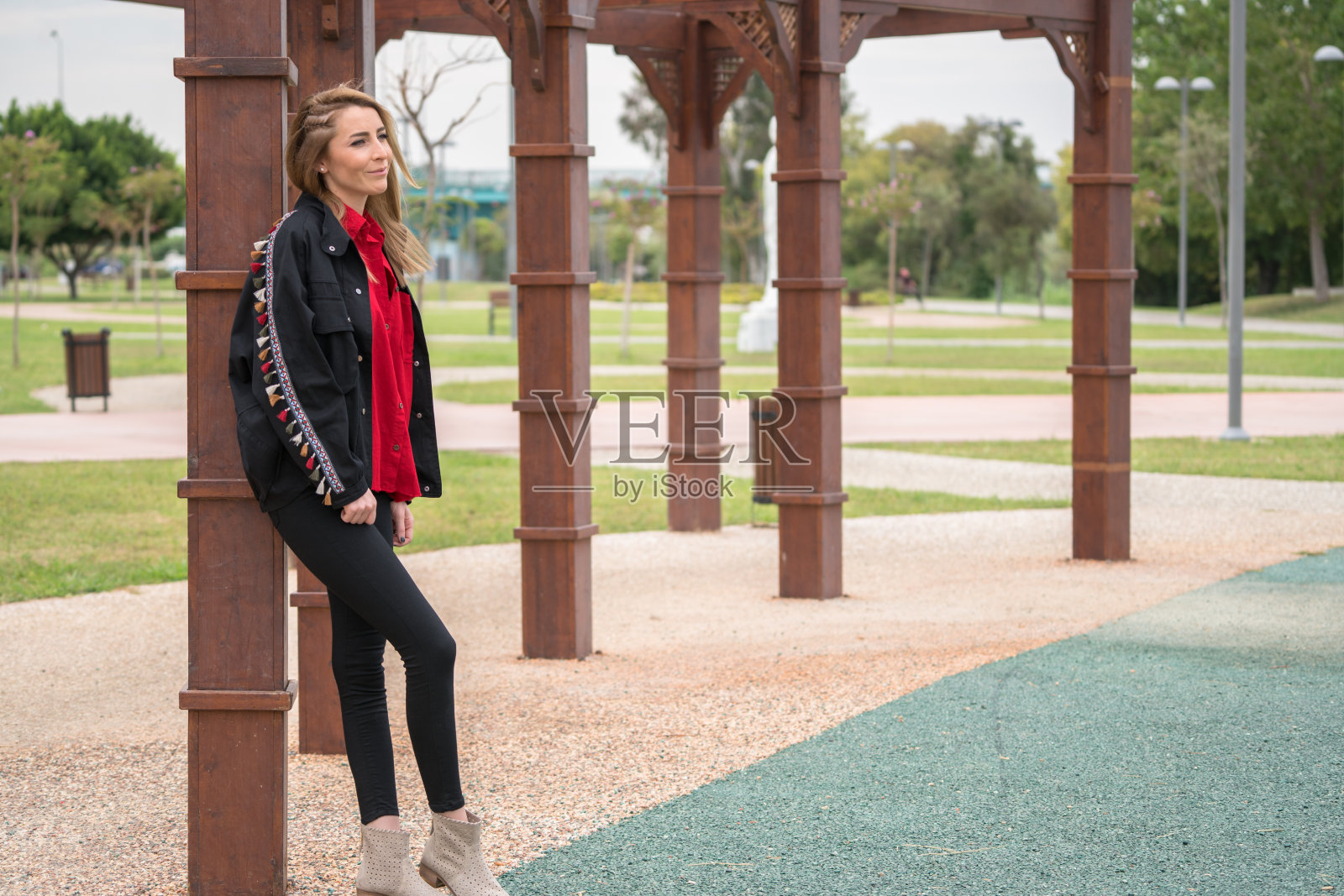 美丽的年轻女子躺在公园的木篱笆上照片摄影图片