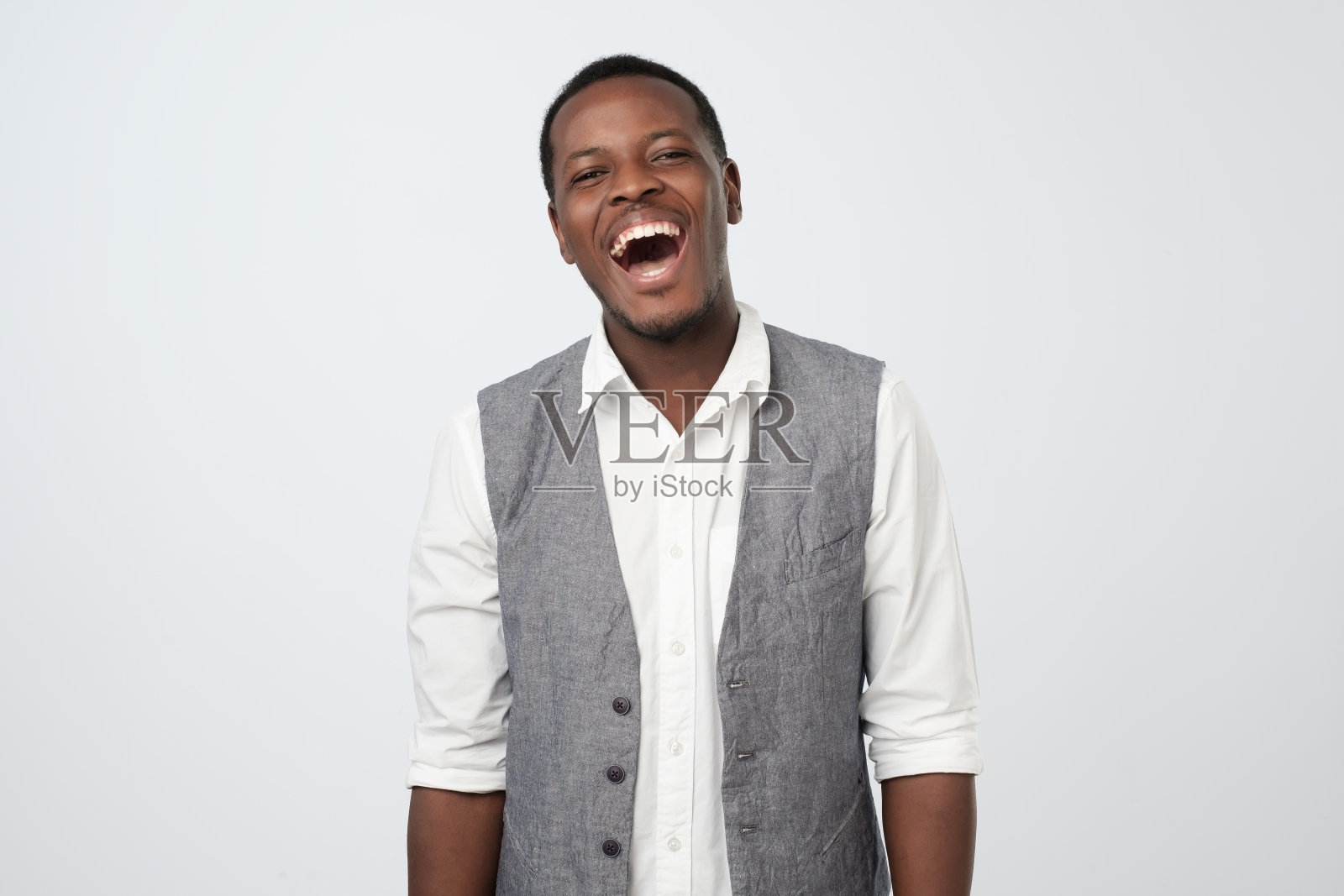 英俊年轻的非洲男性在工作中听到有趣的笑话时大笑照片摄影图片