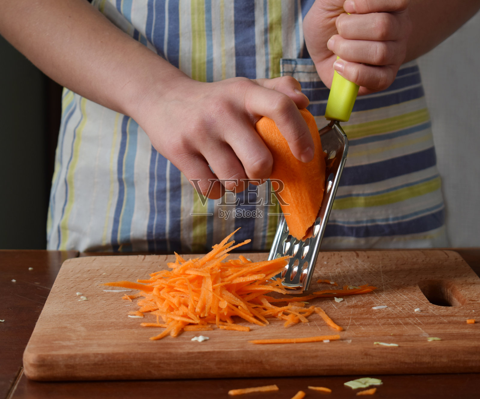 女人在木制的背景上煮泡菜或卷心菜沙拉。步骤2 -切碎的胡萝卜。发酵腌菜食品概念。照片摄影图片