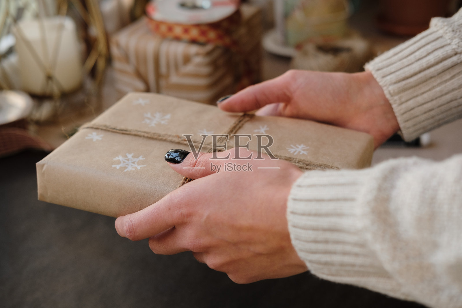 女人拿着圣诞盒子礼物在黑色的背景。女性手与礼物冬季假期。圣诞节、新年、购物、过节准备、捐赠理念照片摄影图片