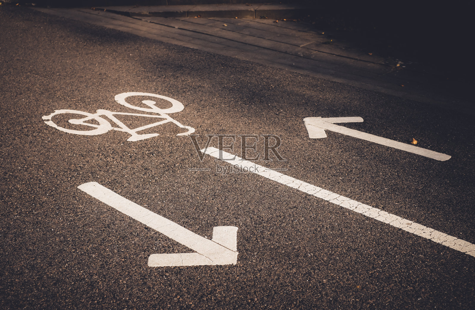 道路上的自行车标志和箭头。白色油漆的自行车在柏油路上。生态绿色城市交通照片摄影图片