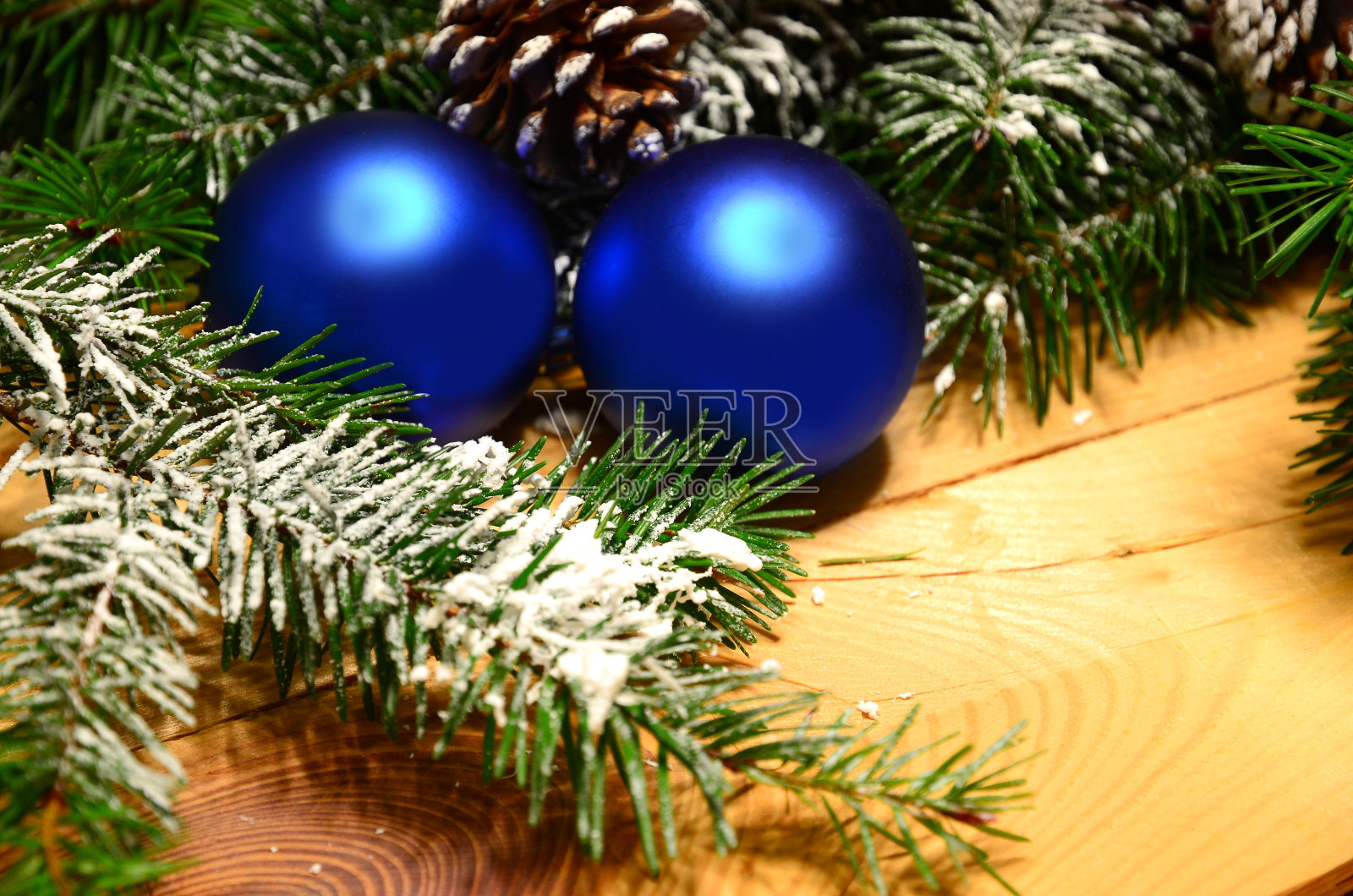 白雪覆盖的圣诞树树枝和圣诞球的木头。圣诞节的背景照片摄影图片
