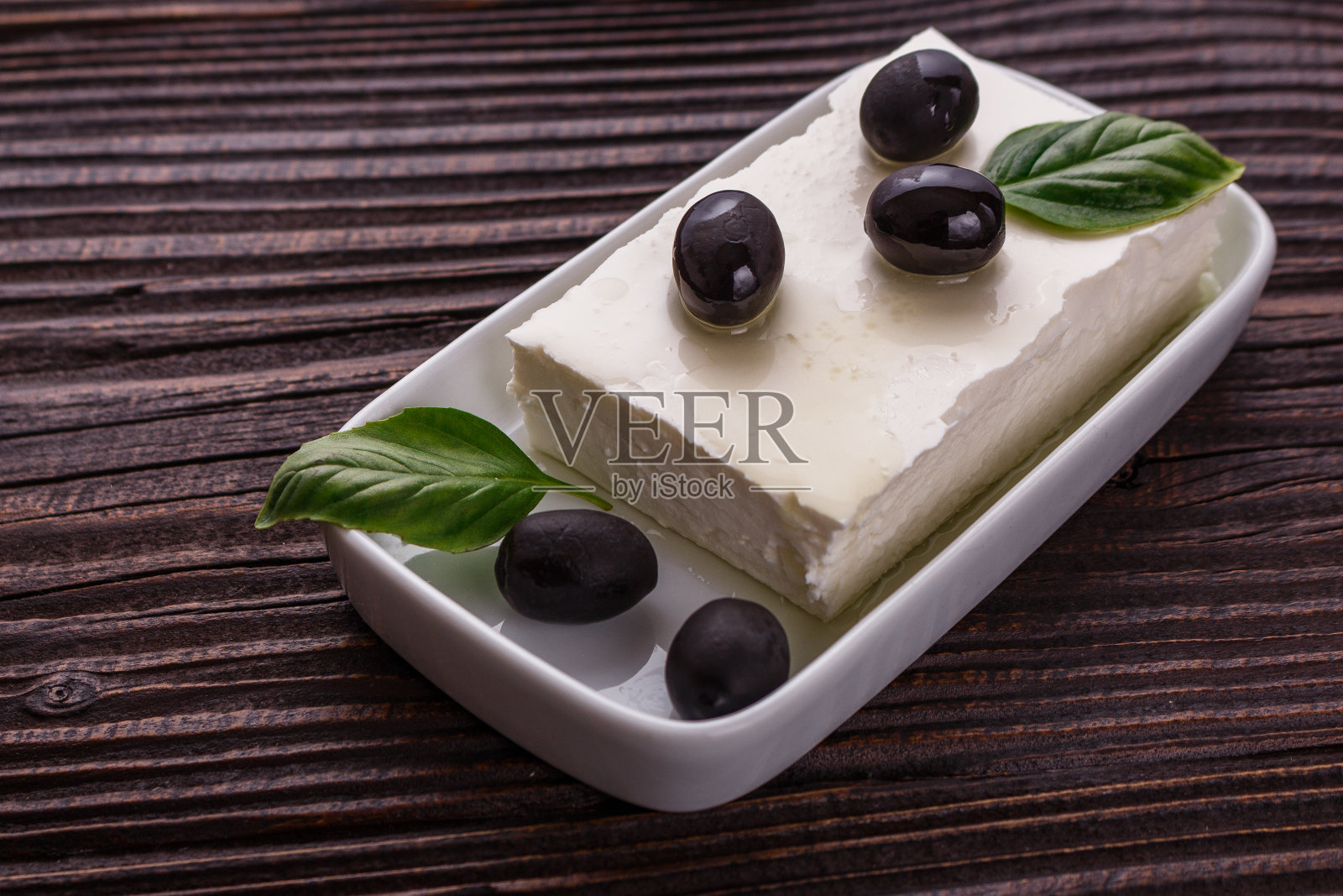 一块羊乳酪放在一个木制的乡村背景上照片摄影图片