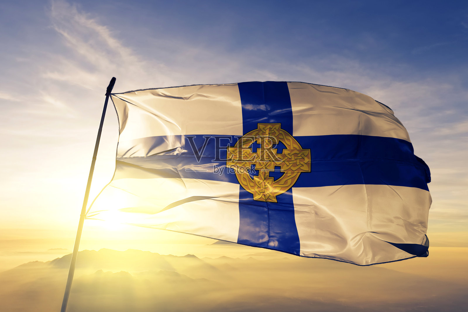 威尔士教堂的旗帜、纺织布、织物在日出的薄雾上飘扬照片摄影图片