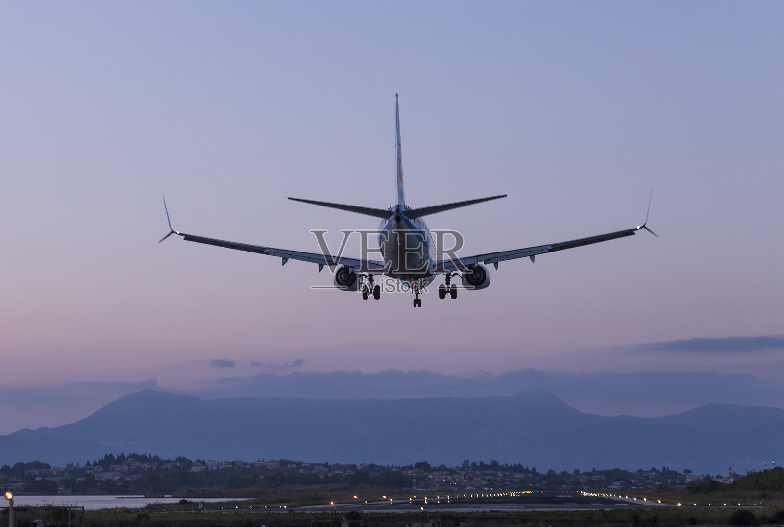 飞机于晚上降落在希腊科孚岛的约阿尼斯卡波狄区机场的跑道上照片摄影图片