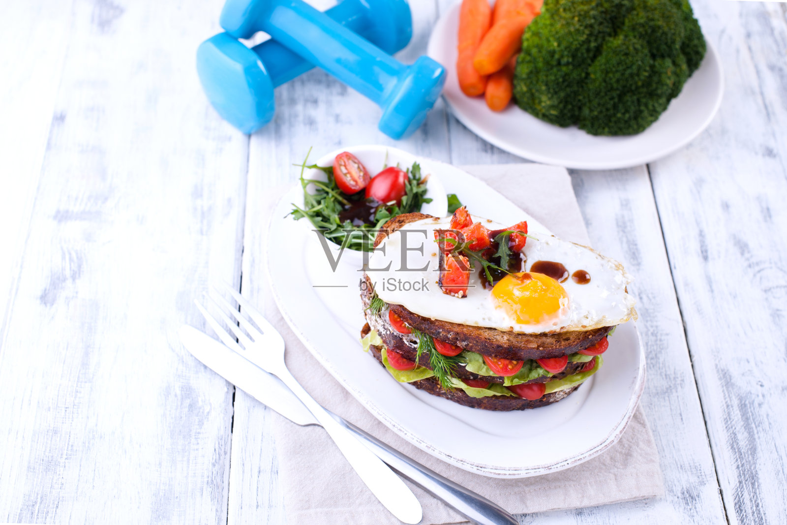 健康午餐,美丽身体,健身营养。食物和运动器材在白色的木制背景上。文本的空闲空间。照片摄影图片