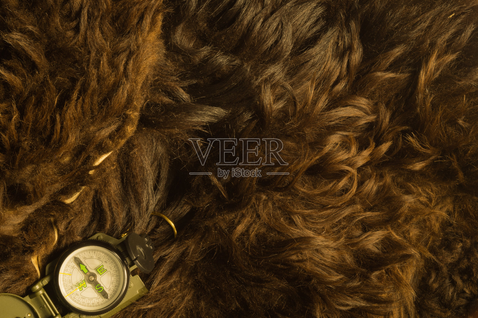 皮毛背景上的现代金属指南针照片摄影图片