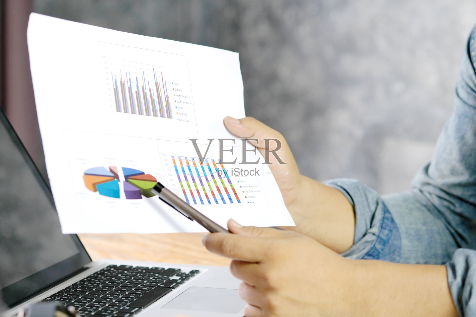 年轻的创意之手在他的办公室里拿起一个工作计划。商业上的成功。照片摄影图片