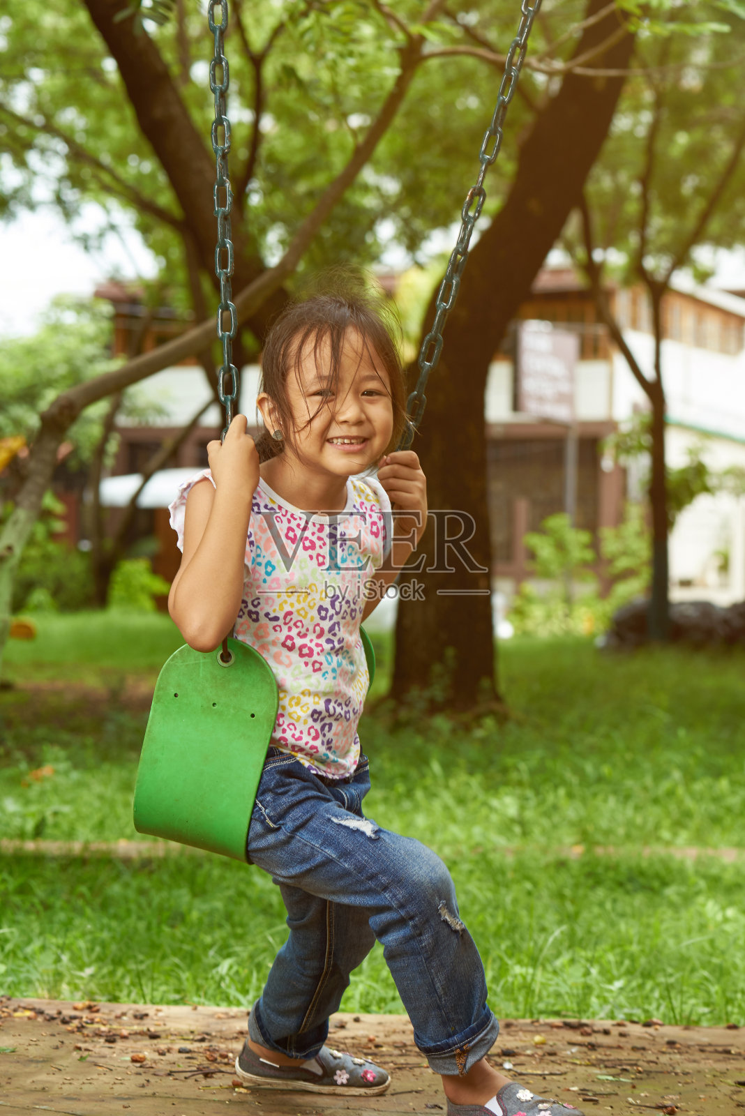 亚洲女孩在秋千上看着镜头照片摄影图片