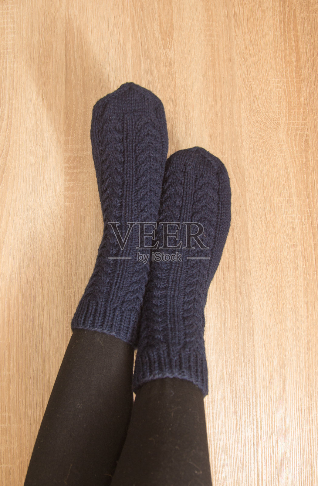 穿着温暖的手工袜子的女人。由天然羊毛纱线编织而成。冬天的衣服。照片摄影图片