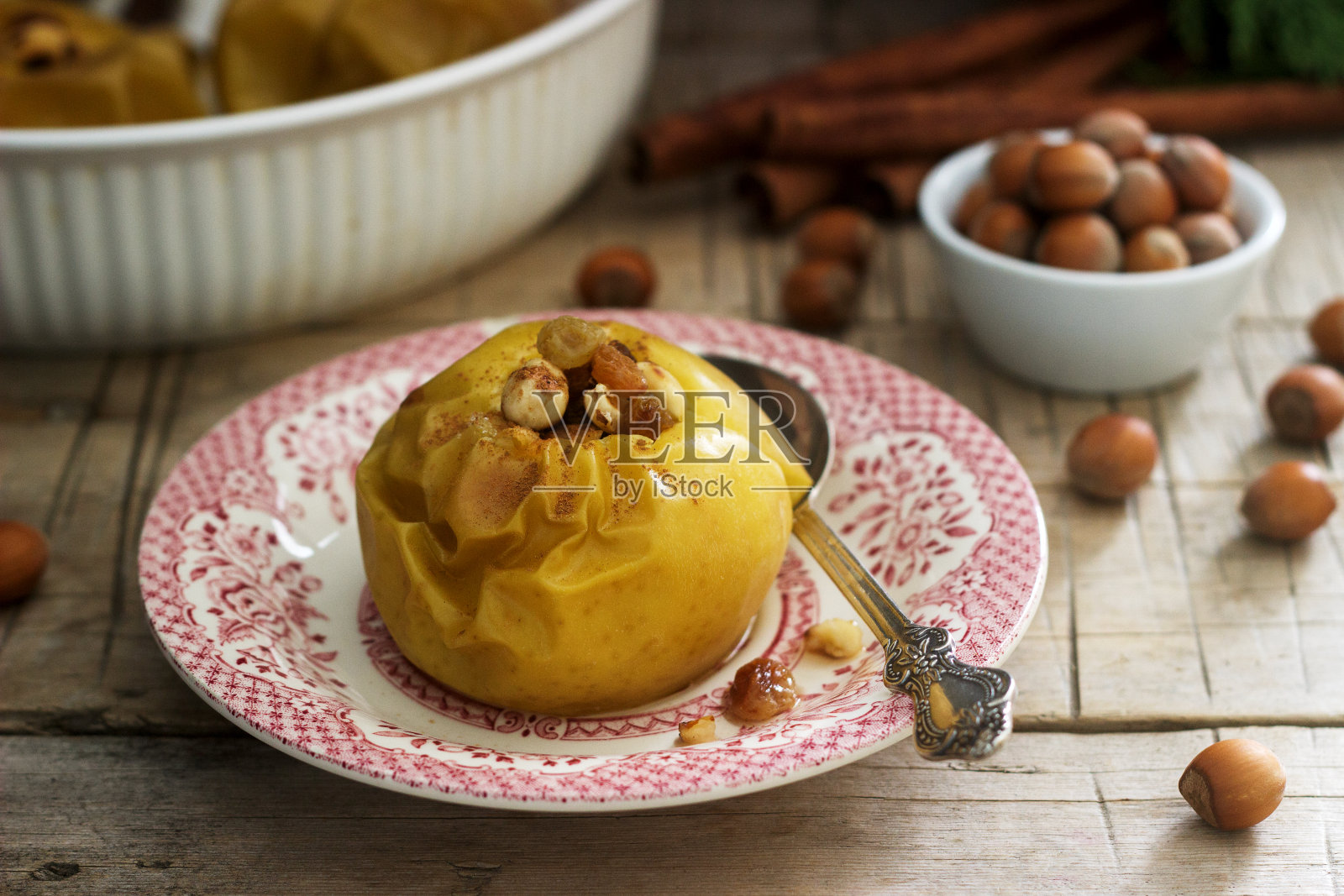 烤苹果葡萄干,榛子和肉桂木背景。乡村风格。照片摄影图片