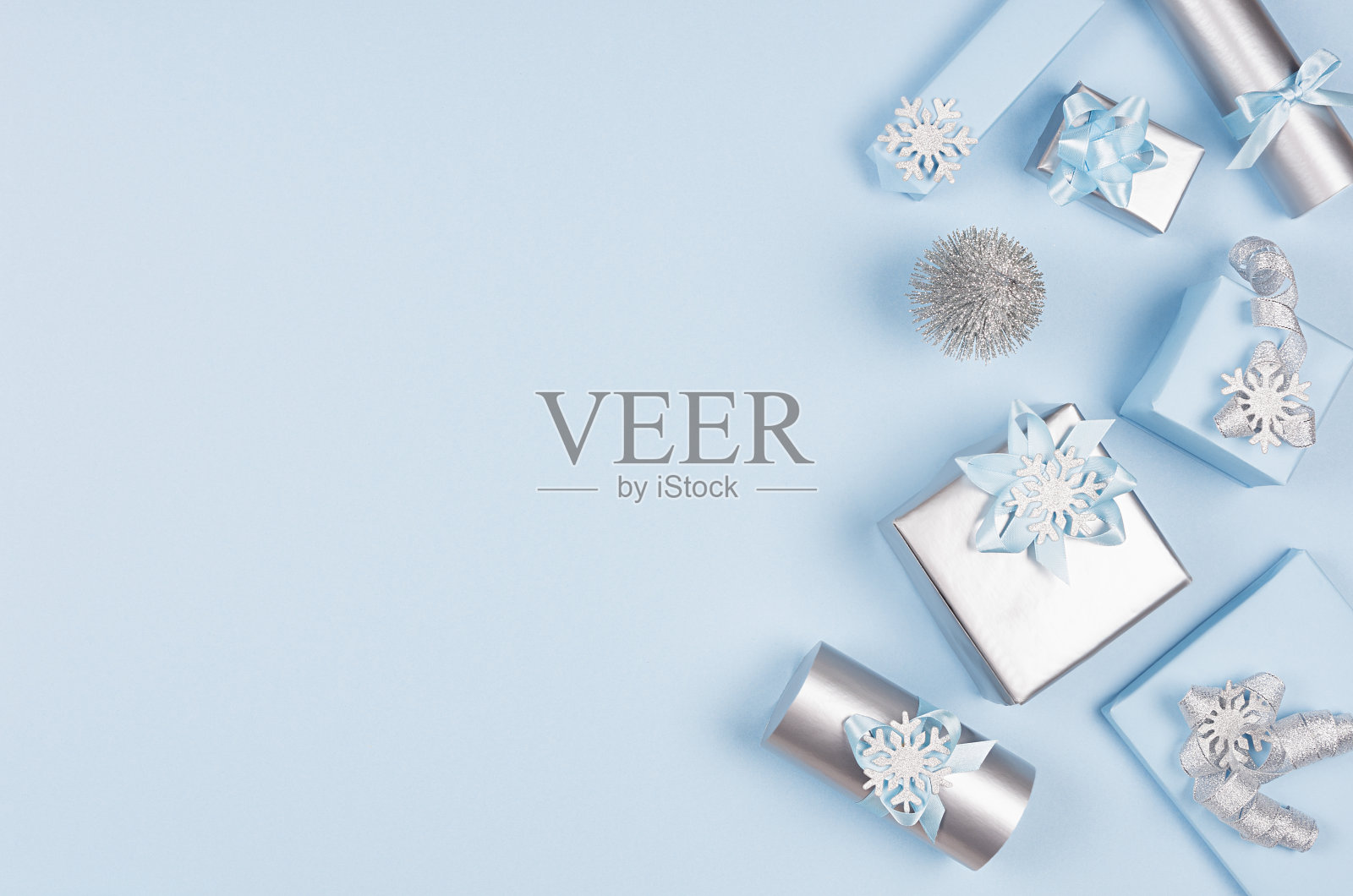 冬季节日背景的广告和设计-蓝色和银色金属礼盒与丝带在柔和的灯光柔和的蓝色背景,复制空间。照片摄影图片