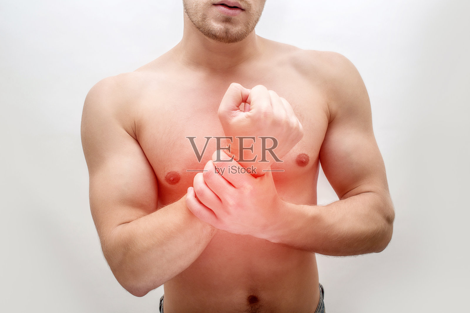 年轻人手腕上有红斑。他握住它的手。家伙是赤膊上阵。孤立在白色背景上。照片摄影图片