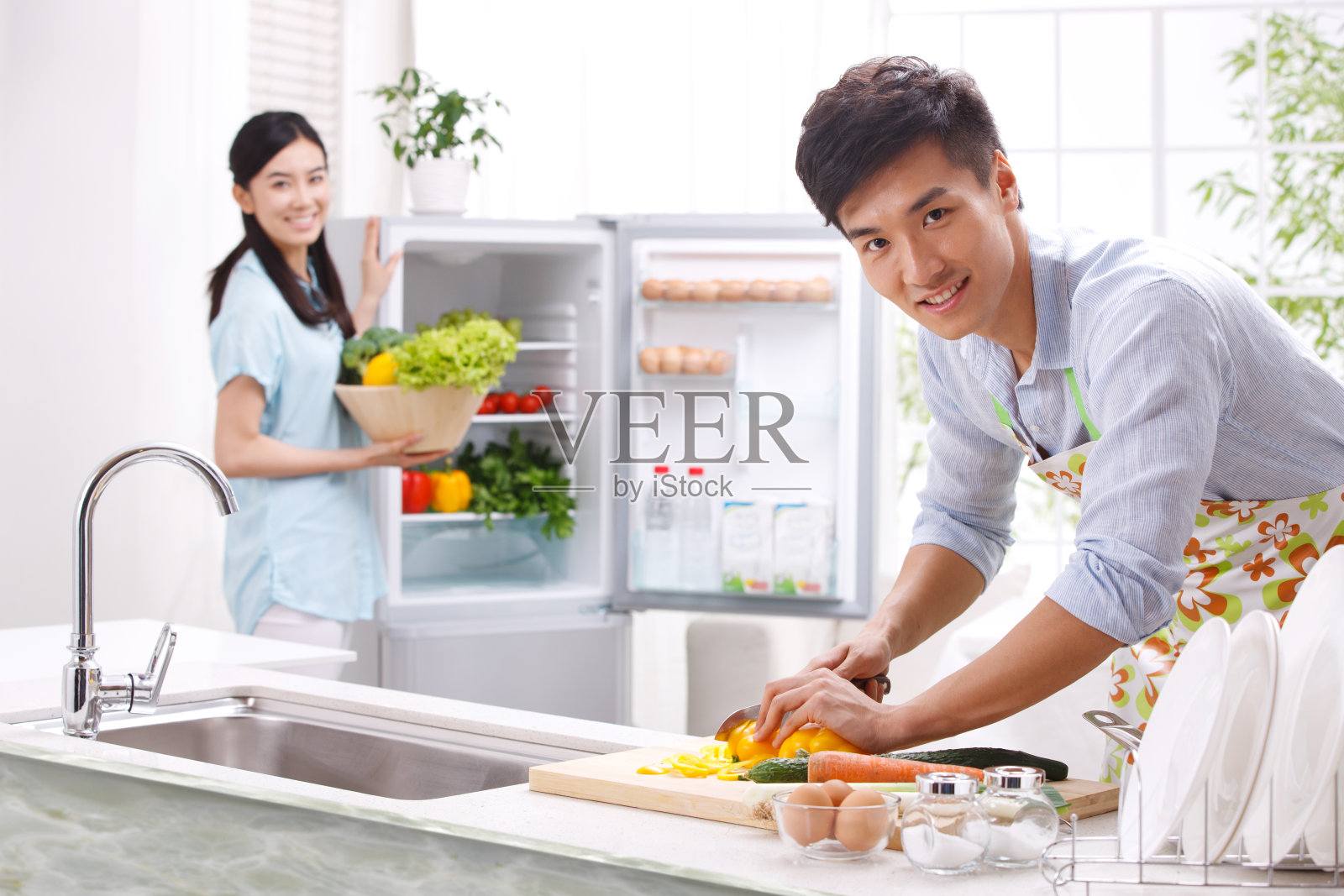 年轻夫妇在厨房做饭照片摄影图片