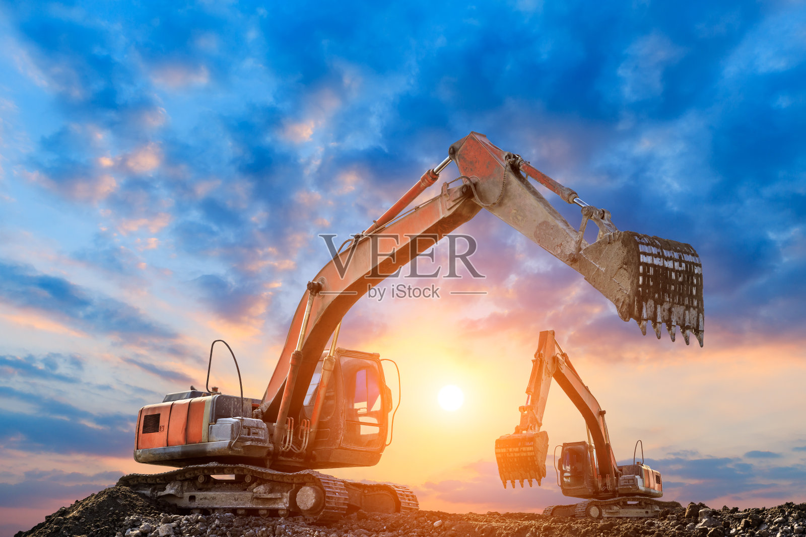 日落时分,两台挖掘机在建筑工地工作照片摄影图片