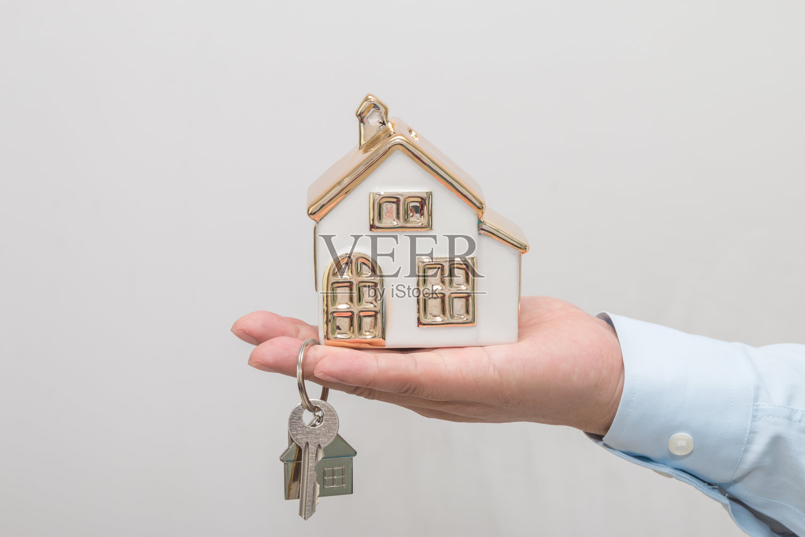 男人手牵房子模型照片摄影图片