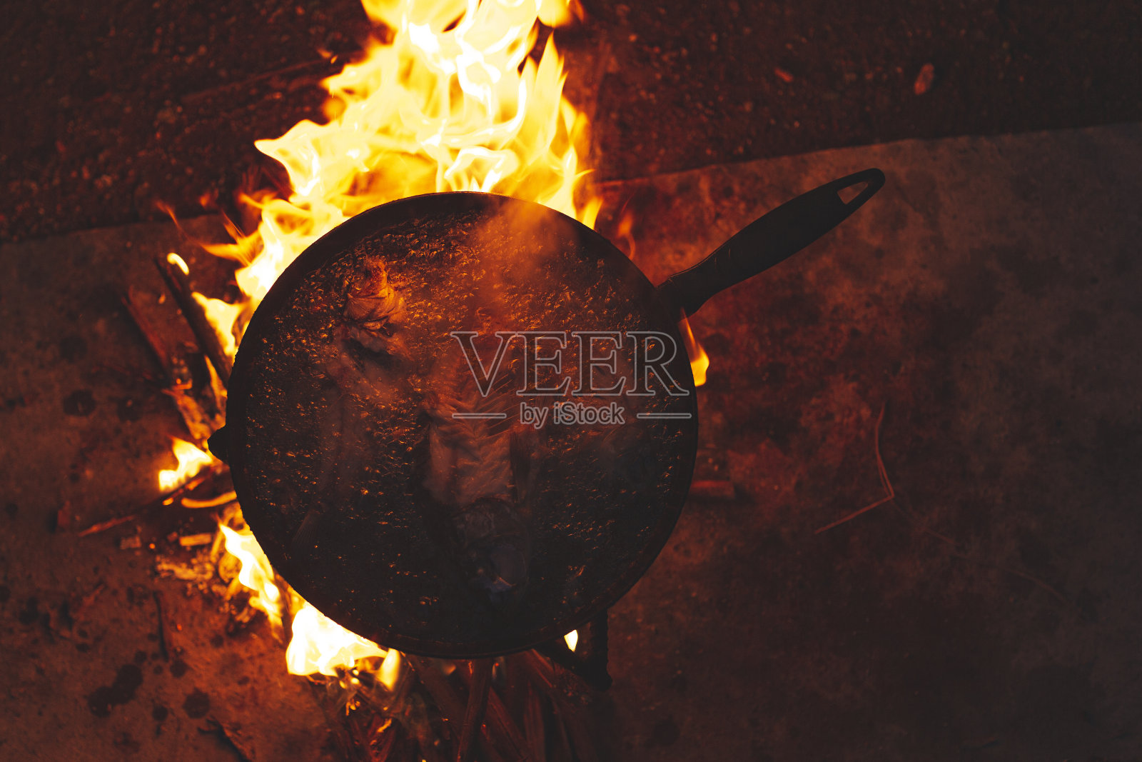 在露天的营火上煎鱼照片摄影图片