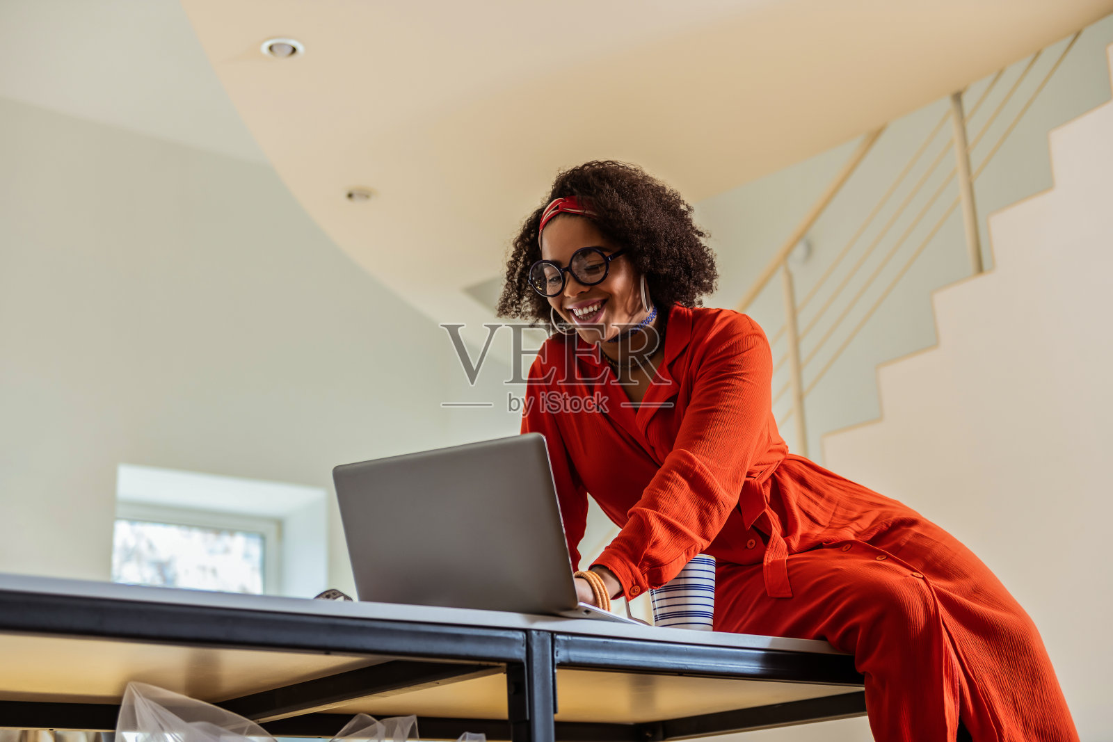 笑容可掬的美女坐在桌子上,手提电脑照片摄影图片